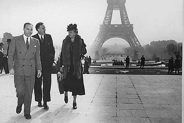Eleanor Roosevelt with two other men walking in front of the Eiffel Tower