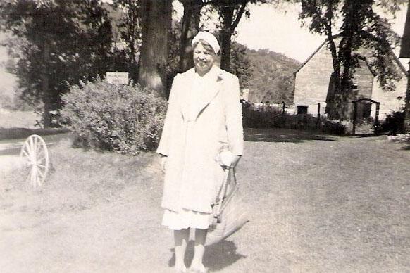 Eleanor Roosevelt standing outside in a skirt suit and hat
